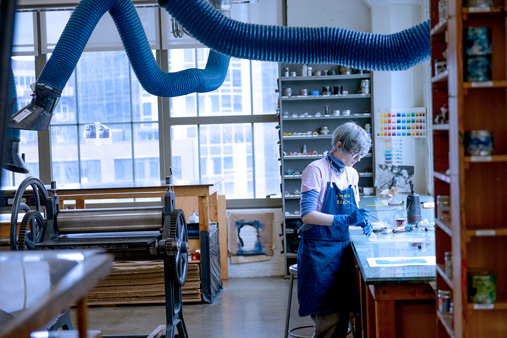 Art Student wearing apron working in large urban studio in Cornish Main campus