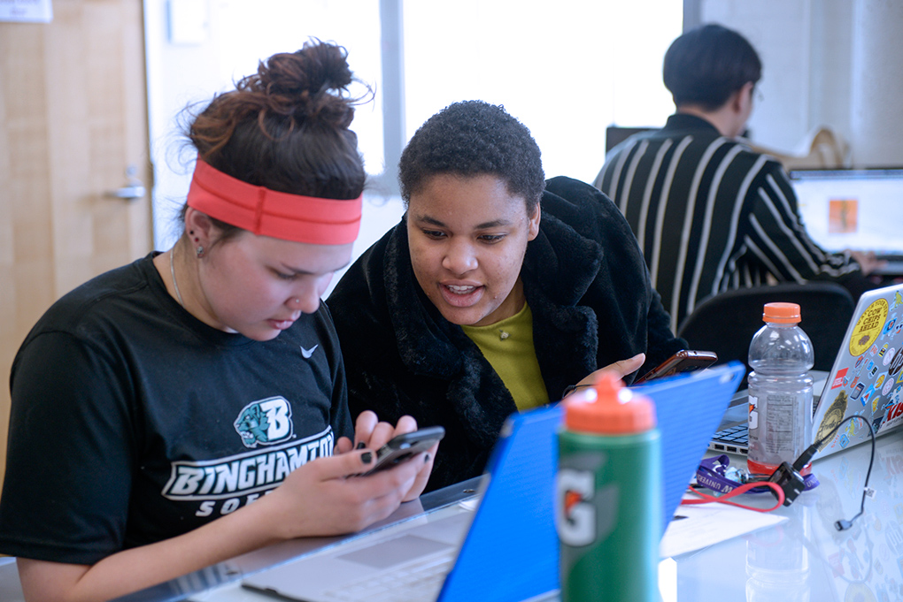 Art Students sitting together while working on and discussing a project