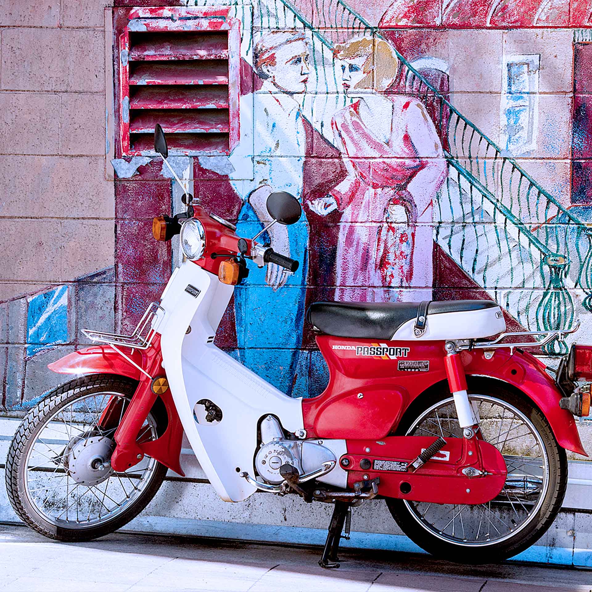 Red moped against colorful mural