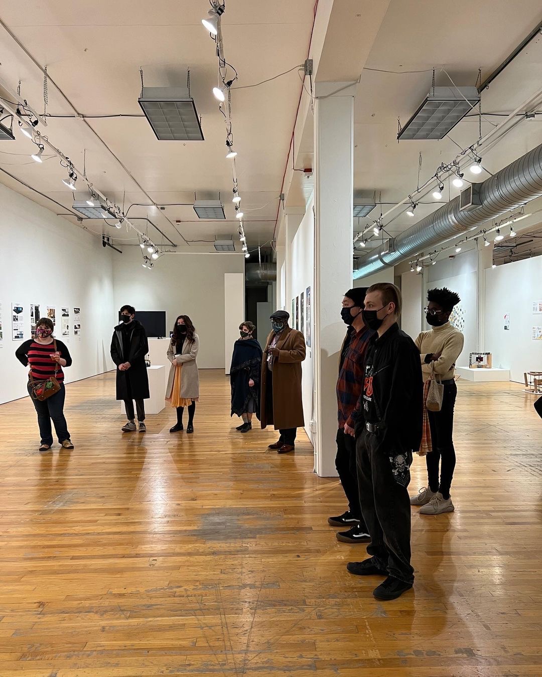 A group of people standing in a gallery.