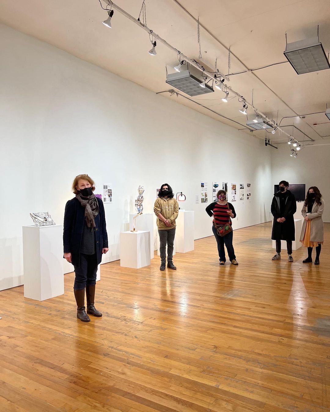 A group of people standing in a gallery.