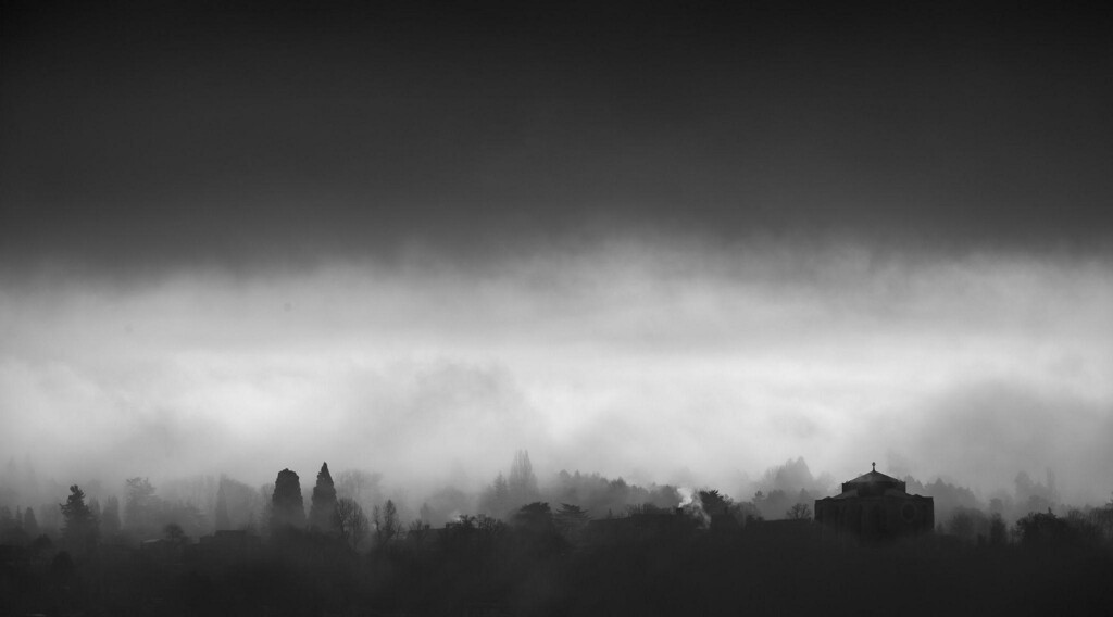 Black and white photo of Seattle's Capital Hill with rolling dark clouds.