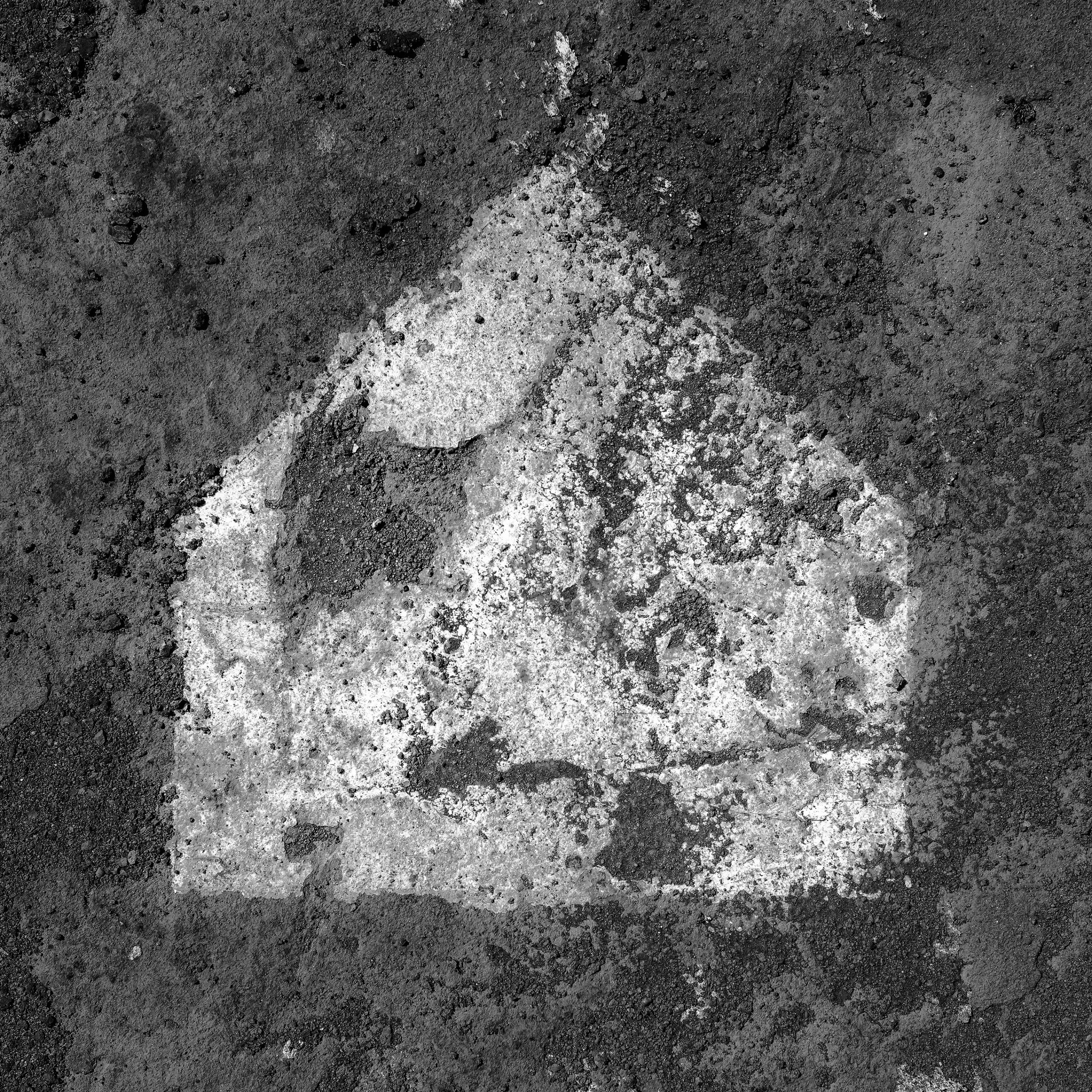 Black and white image of a house-like painted shape on a rough asphalt surface.