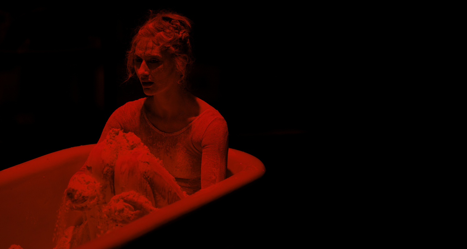 figure in a bathtub in red light