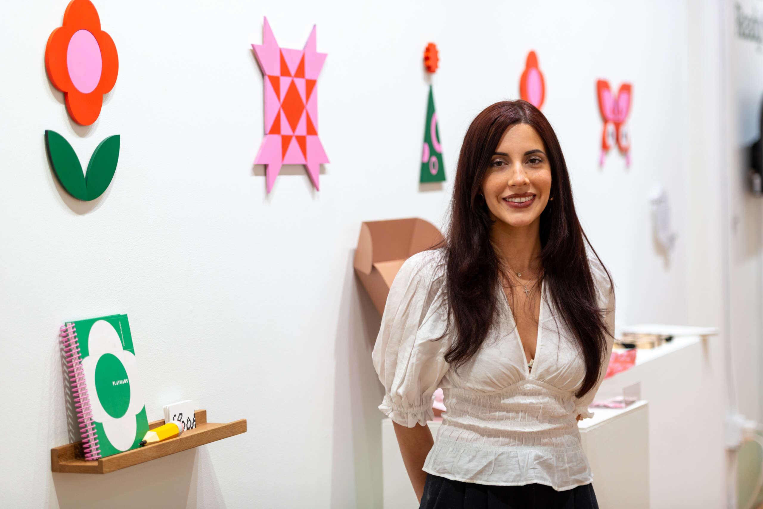 Photo by Winnie Westergard. Student stands in front of their BFA project at the 2026 Design BFA Exhibition