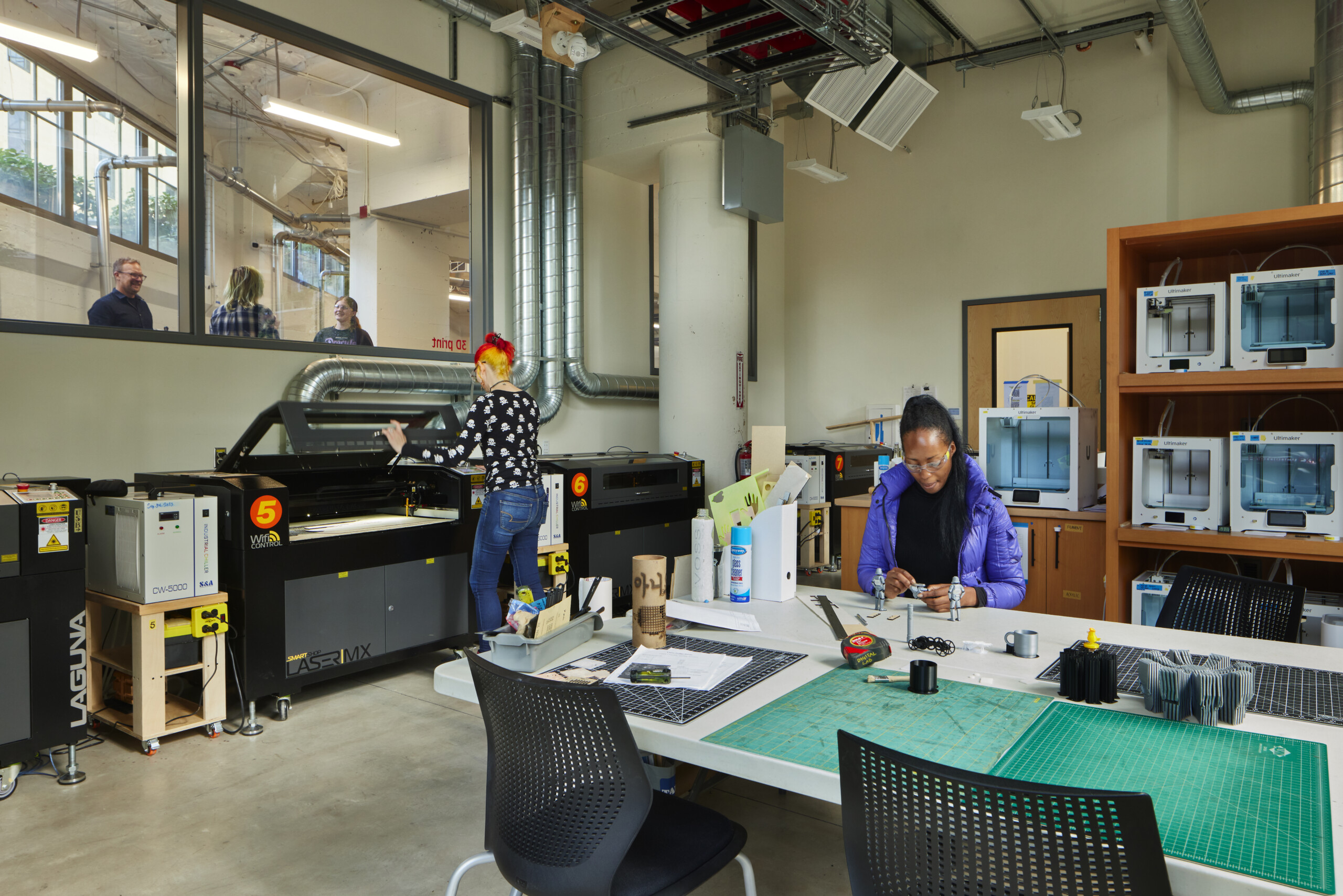 Two people work in the Jon and Mary Shirley Fabrication Studio